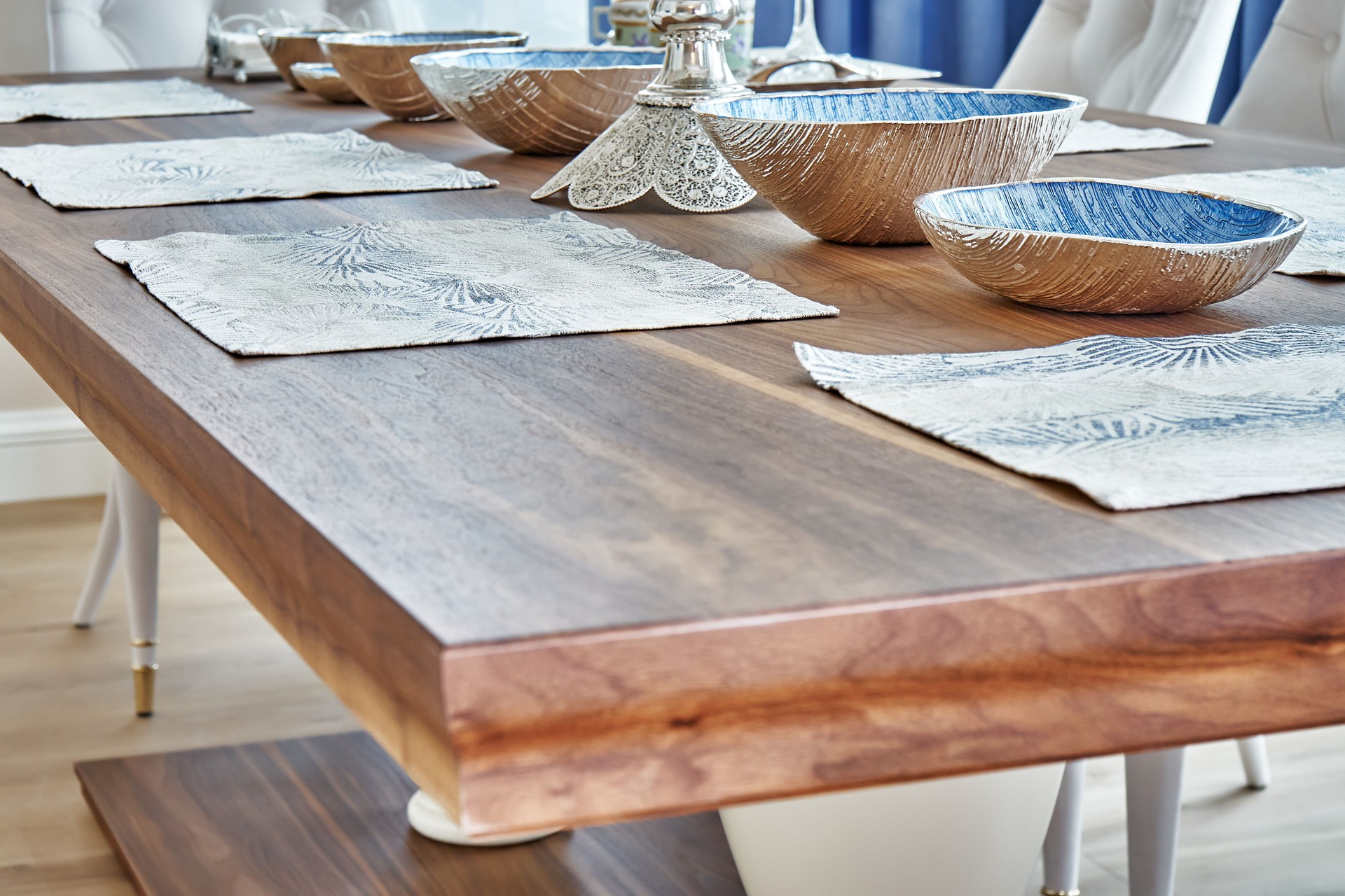 Wooden dinner table with dishware. Blurred foreground